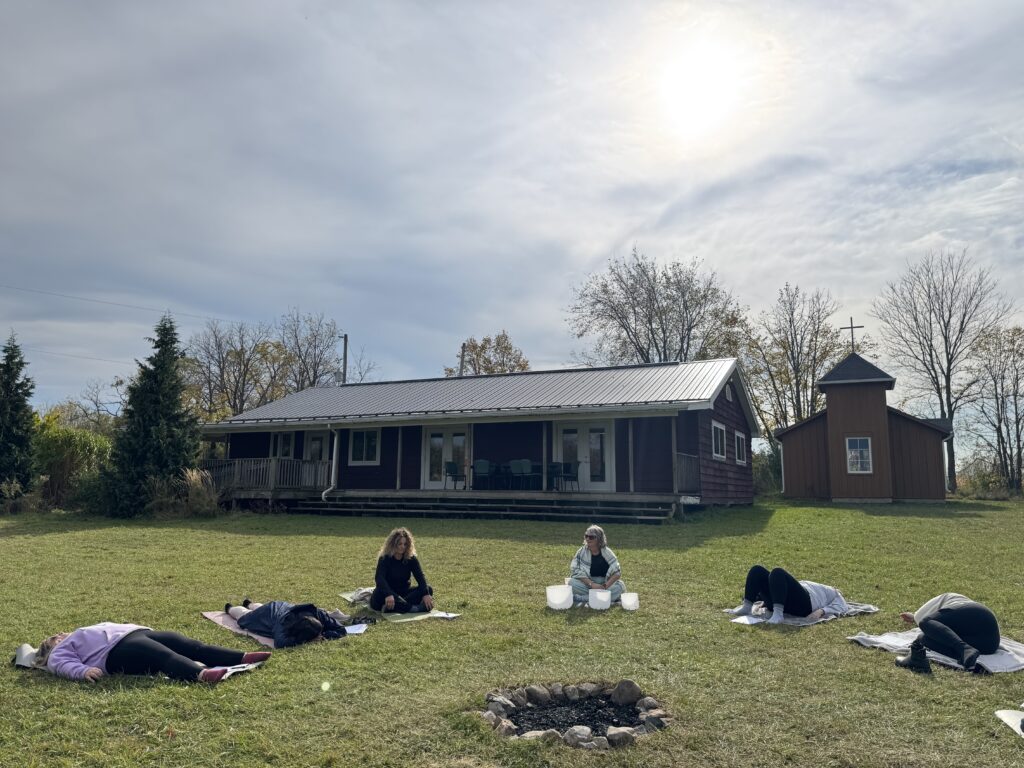 women in a circle with the facilitator performing sound bathing